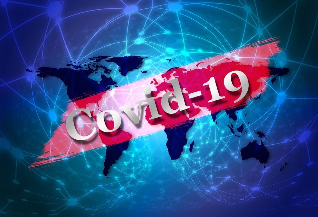 A world map with network lines and the text "Covid-19" in large letters across the center, symbolizing the global spread of the coronavirus pandemic and highlighting challenges in managing an Airbnb during the Covid-19 outbreak.