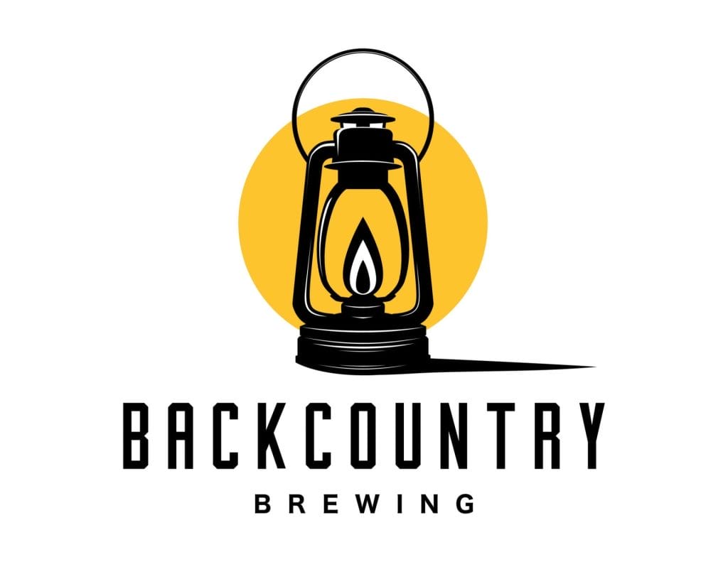 Logo for Backcountry Brewing, featured in the Sea to Sky Brewery Guide, displays a black lantern with a yellow circle background and the company name in bold, modern letters beneath the image.