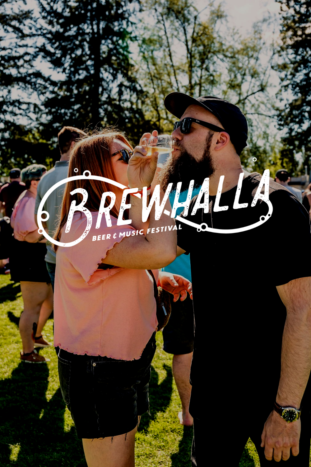 Two people stand outdoors at a festival, one sipping from a glass. The "Brewhalla Beer & Music Festival" logo is overlaid, inviting you to discover more about us and join the celebration.