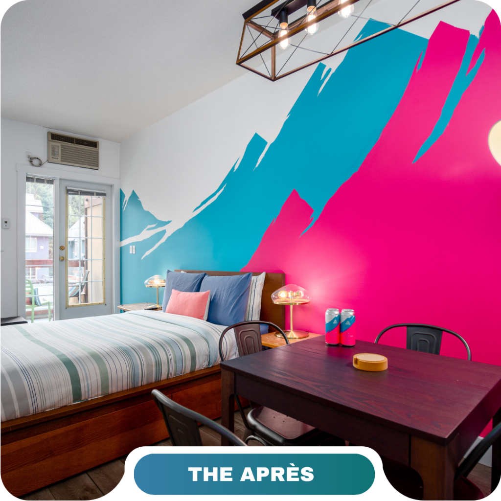 A modern bedroom with a striped bed, wooden furniture, and a bold blue and pink mountain mural on the wall; "THE APRÈS" label at the bottom—perfect inspiration for vacation rentals in Whistler.