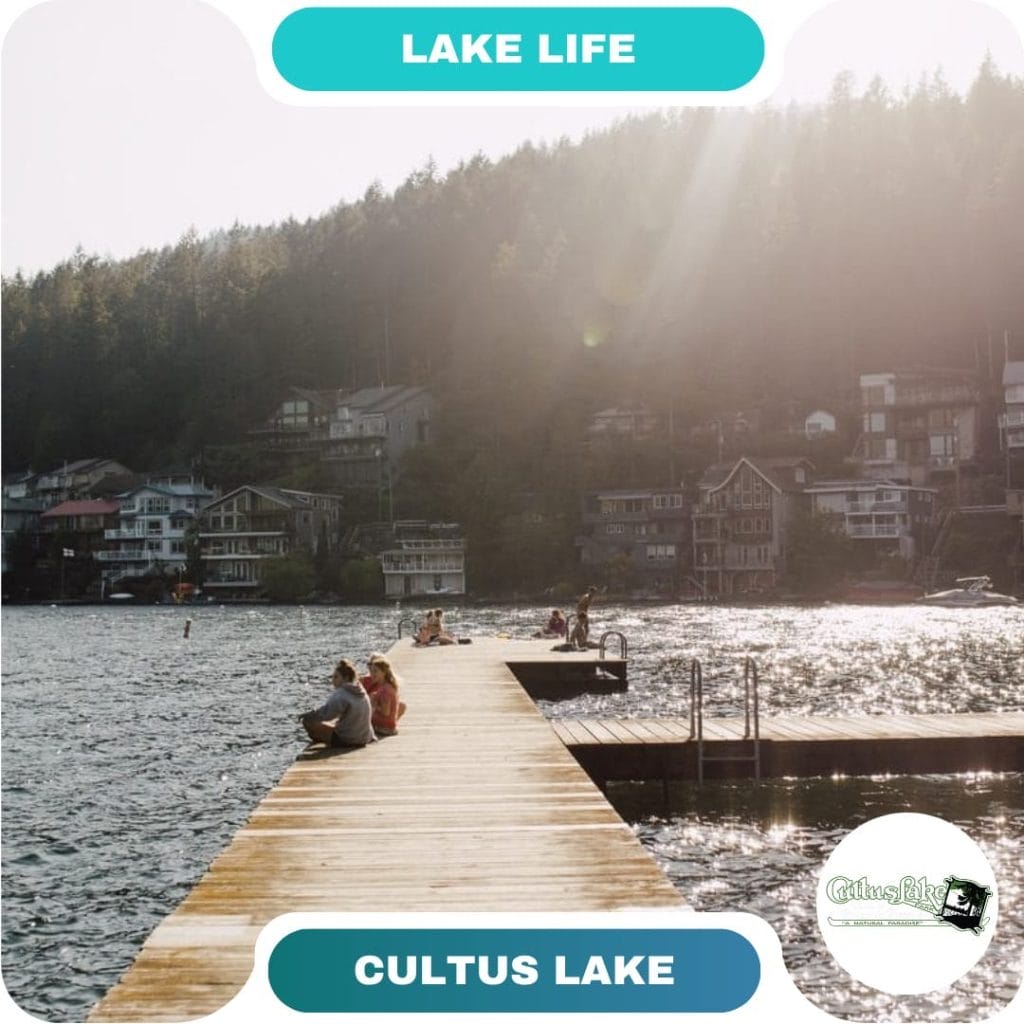 Guests sit and relax on a wooden dock extending into the lake, with houses and forested hills in the background at one of Cultus Lake’s beautiful destinations.