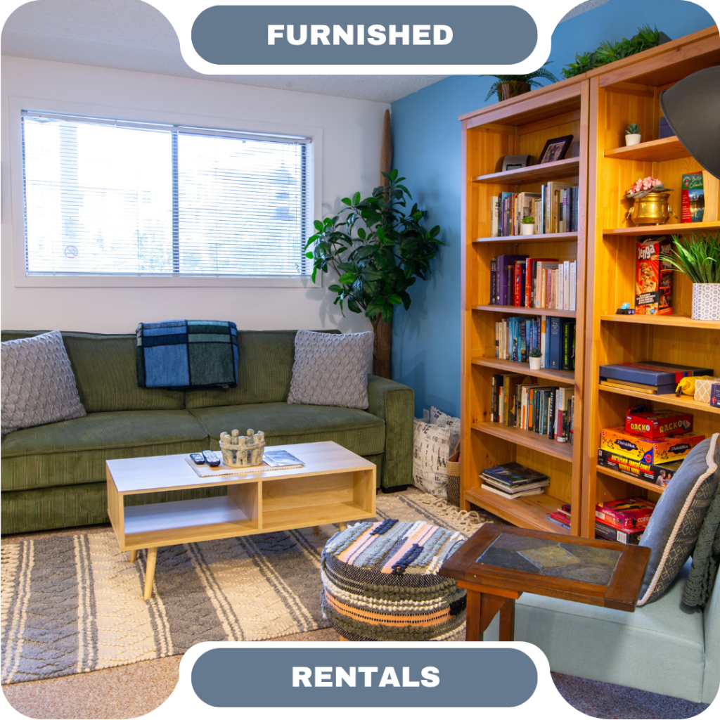 A living room with a green sofa, coffee table, bookshelf filled with books and games, indoor plant, window, and woven ottoman. Text reads “Furnished Rentals—perfect for vacation rentals in Whistler.”.