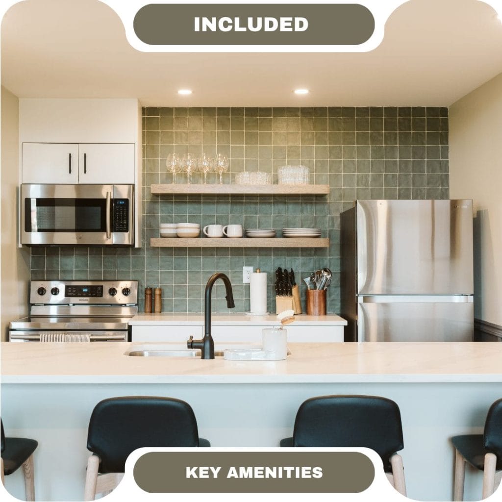 Modern kitchen in vacation rentals in Whistler features stainless steel appliances, open shelving, a green tile backsplash, and a countertop with three chairs; labeled "Included Key Amenities.